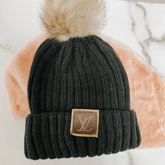 Black knit beanie with faux fur pom and designer patch